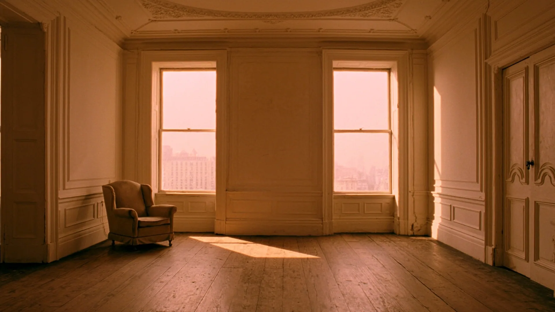 An empty Georgian living room with tall sash windows and warm afternoon light pooling on aged wooden floorboards, a single upholstered armchair to one side